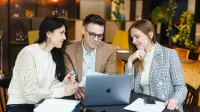 Zarządzanie projektami i organizacjami zwinnymi | Studia I stopnia w Warszawie | Uniwersytet WSB Merito Warszawa: trzy osoby patrzące w ekran laptopa