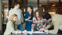 Zarządzanie zespołami rozproszonymi | Studia podyplomowe w Warszawie | Uniwersytet WSB Merito Warszawa: grupa ludzi pracująca nad projektem
