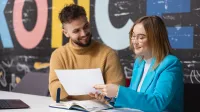 International HR operations and Payroll | Studia podyplomowe w Warszawie | Uniwersytet WSB Merito Warszawa: Chłopak z dziewczyną rozmawiają przy stole po zajęciach