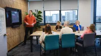 Projektowanie gier komputerowych | Studia podyplomowe w Warszawie | Uniwersytet WSB Merito Warszawa: grupa osób słuchające przedstawienia projektu