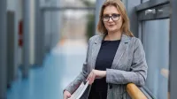 Psychologia w biznesie | Studia podyplomowe w Warszawie | Uniwersytet WSB Merito Warszawa: uśmiechnięta kobieta trzymająca książki