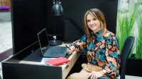 Product Manager w erze AI - zarządzanie produktami cyfrowymi | Studia podyplomowe w Warszawie | Uniwersytet WSB Merito Warszawa: uśmiechnięta kobieta przy komputerze