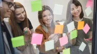 Team coaching i facylitacja | Studia podyplomowe w Warszawie | Uniwersytet WSB Merito Warszawa: grupa osób przyklejająca karteczki
