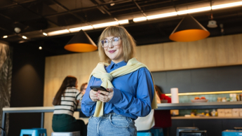 Marketing i sprzedaż | Studia II stopnia w Warszawie | Uniwersytet WSB Merito Warszawa: Studentka w okularach z telefonem
