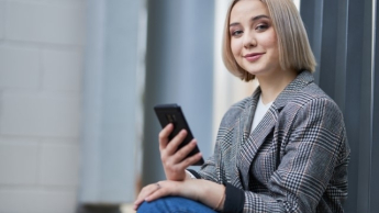 Sztuczna inteligencja w komunikacji biznesowej | Studia II stopnia w Warszawie | Uniwersytet WSB Merito Warszawa: Studentka z telefonem