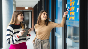 Programowanie aplikacji Java | Studia podyplomowe w Warszawie | Uniwersytet WSB Merito Warszawa: dwie kobiety analizujące notatki zapisane na kolorowych karteczkach