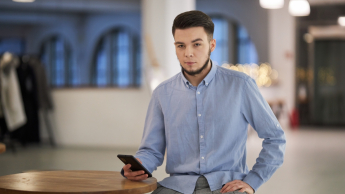 Analityk finansowy | Studia podyplomowe w Warszawie | Uniwersytet WSB Merito Warszawa: mężczyzna trzymający telefon w ręce