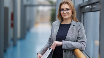 Psychologia w biznesie | Studia podyplomowe w Warszawie | Uniwersytet WSB Merito Warszawa: uśmiechnięta kobieta trzymająca książki
