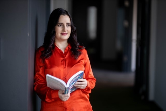 Zarządzanie zasobami ludzkimi | Studia II stopnia w Warszawie | Uniwersytet WSB Merito Warszawa: Stojąca studentka z książką 