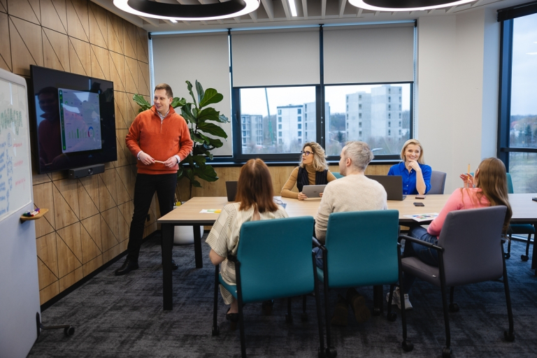 Zintegrowany system informatyczny SAP ERP | Studia podyplomowe w Warszawie | Uniwersytet WSB Merito Warszawa: grupa osób słuchające przedstawienia projektu