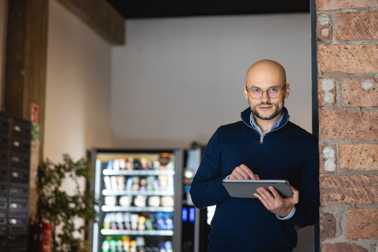 Tester automatyzujący | Studia podyplomowe w Warszawie | Uniwersytet WSB Merito Warszawa: mężczyzna trzymający tablet w ręce