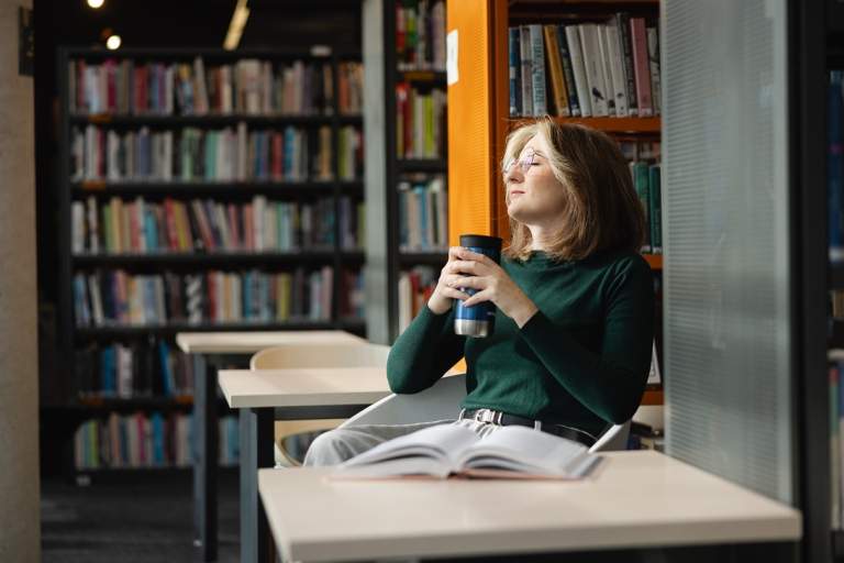 Dydaktyka języków obcych | Studia podyplomowe w Warszawie | Uniwersytet WSB Merito Warszawa: Studentka odpoczywająca w bibliotece.