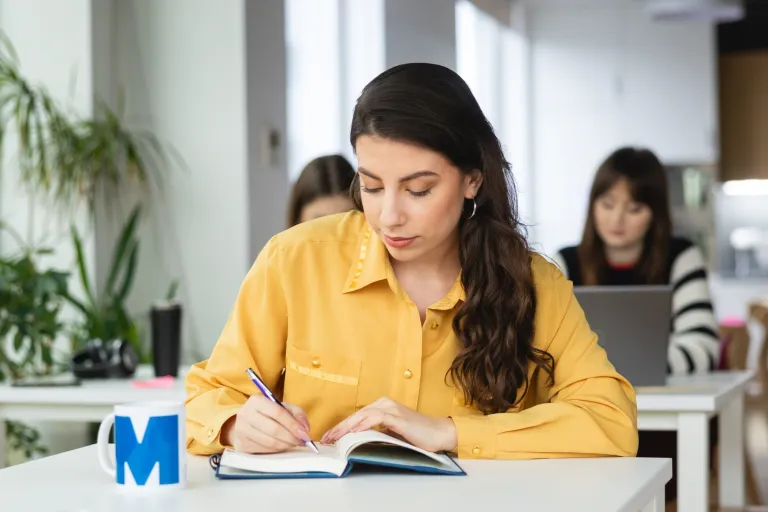 Administracja | Studia I stopnia w Warszawie | Uniwersytet WSB Merito Warszawa: studentka z książką 