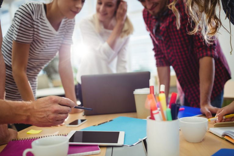 Cloud DevOps Engineer Administrator | Studia podyplomowe we Wrocławiu | Uniwersytet WSB Merito we Wrocławiu: Grupa osób pracująca przy stole z zeszytami i długopisami