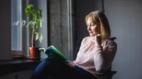 Akademia przywództwa kobiet | Studia podyplomowe we Wrocławiu | Uniwersytet WSB Merito we Wrocławiu: uczestniczka studiów podyplomowych czytająca książkę