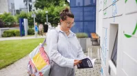 Customer Experience Management | Studia podyplomowe we Wrocławiu | Uniwersytet WSB Merito we Wrocławiu: studentka odbierająca książkę z książkomatu