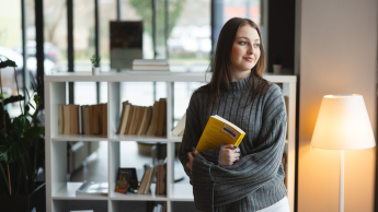Architekt rozwiązań IT w chmurze obliczeniowej | Studia podyplomowe we Wrocławiu | Uniwersytet WSB Merito we Wrocławiu: studentka trzymająca książkę