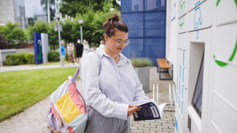 Customer Experience Management | Studia podyplomowe we Wrocławiu | Uniwersytet WSB Merito we Wrocławiu: studentka odbierająca książkę z książkomatu