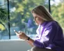 Zapraszamy na Śniadanie Biznesowe | Aktualności | Uniwersytet WSB Merito we Wrocławiu: Dziewczyna patrząca na smartfon