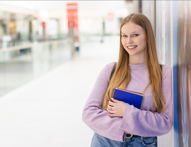 Pedagogika opiekuńczo-wychowawcza z nowoczesnymi technologiami w edukacji | Studia I stopnia we Wrocławiu | Uniwersytet WSB Merito we Wrocławiu: studentka trzymająca notatnik