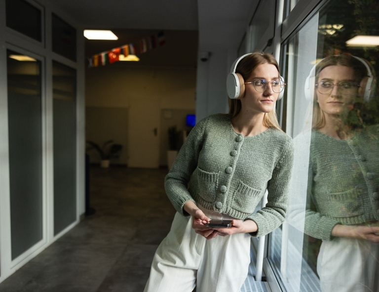 Trendy & design w marketingu | Studia II stopnia ze studiami podyplomowymi  | Uniwersytet WSB Merito we Wrocławiu: studentka słuchająca muzyki w słuchawkach