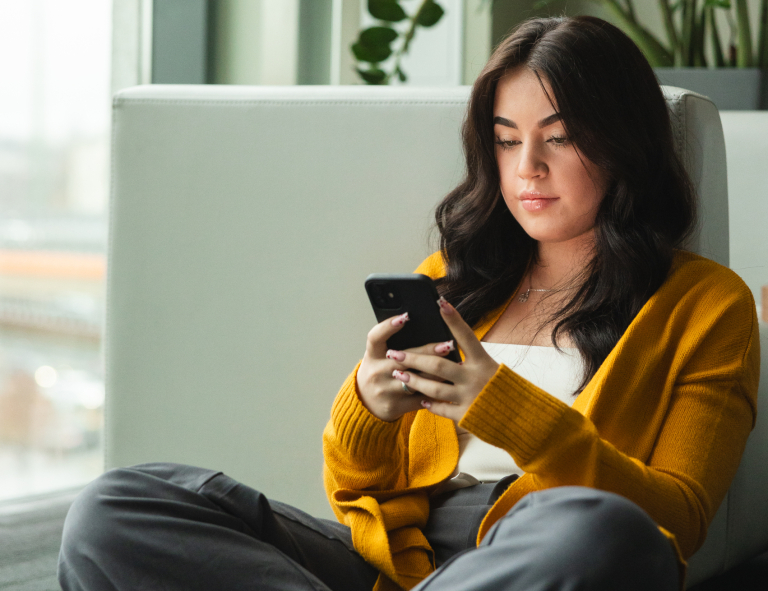 Content Marketing i storytelling 360° | Studia I stopnia we Wrocławiu | Uniwersytet WSB Merito we Wrocławiu: studentka używająca telefonu