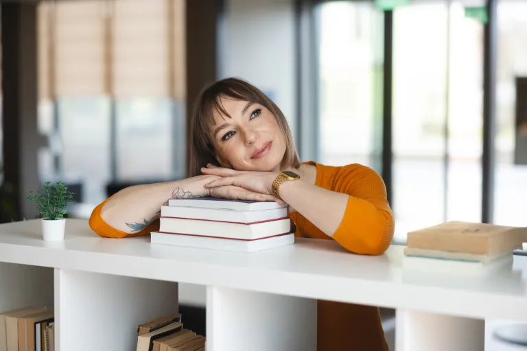 Rachunkowość i podatki | Studia I stopnia we Wrocławiu | Uniwersytet WSB Merito we Wrocławiu: studentka opierająca się o stertę książek