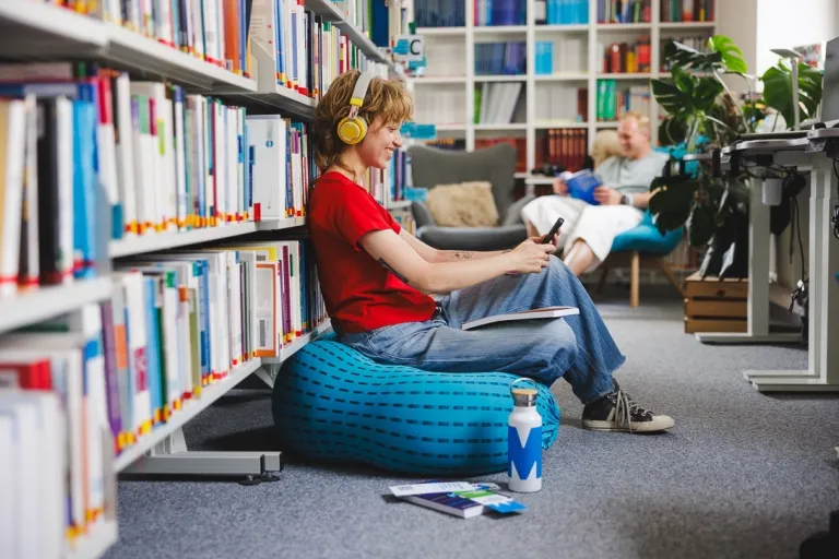 Dietetyka kliniczna i dietoterapia chorób niezakaźnych | Studia II stopnia we Wrocławiu | Uniwersytet WSB Merito we Wrocławiu: studentka słuchająca muzyki w bibliotece