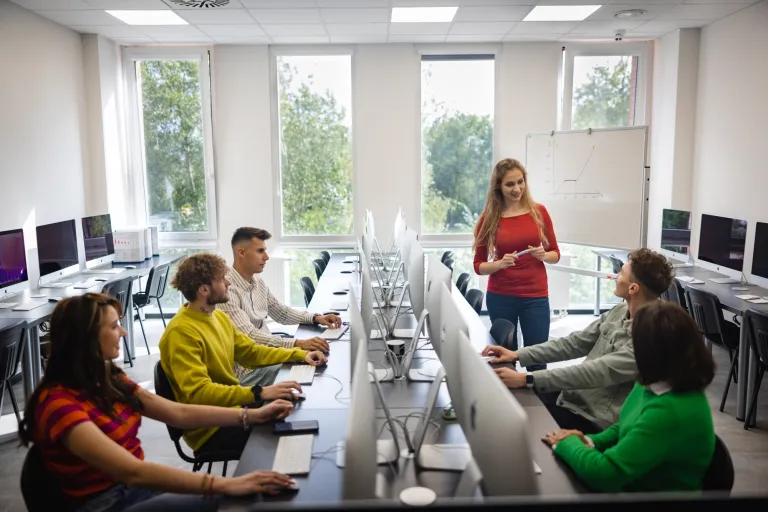 Dyplomacja i protokół dyplomatyczny | Studia I stopnia we Wrocławiu | Uniwersytet WSB Merito we Wrocławiu: studenci podczas zajęć w pracowni komputerowej apple imac