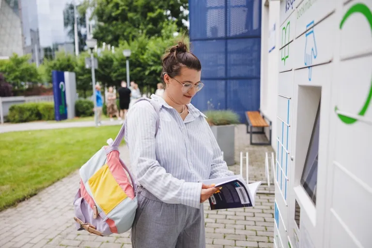 Turystyka zdrowotna, Wellness i dietetyka | Studia I stopnia we Wrocławiu | Uniwersytet WSB Merito we Wrocławiu: studentka odbierająca książkę z książkomatu