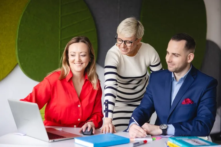 Zarządzanie talentami dla menedżerów - zapraszamy na webinar! | Aktualności | Uniwersytet WSB Merito we Wrocławiu: Grupa dorosłych siedzi wspólnie przy laptopie i biurku